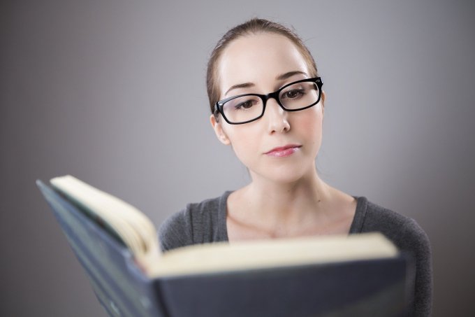 kobieta w okularach czytająca książkę